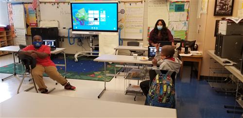 Two students and a teacher in a classroom 